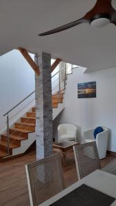 - un salon avec un escalier, une table et des chaises dans l'établissement Cap Saint Martin Marina, au Cap d'Agde