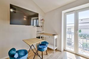 a room with a desk and two blue chairs at Magnifique appartement à proximité de la plage in Nice