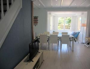 a dining room with a television and a table and chairs at Maison Castine - Maison pour 6 in Saint-Cast-le-Guildo