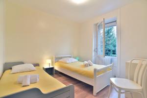 a bedroom with two beds and a window at Maison Castine - Maison pour 6 in Saint-Cast-le-Guildo