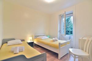 una camera da letto con due letti e una finestra di Maison Castine - Maison pour 6 a Saint-Cast-le-Guildo