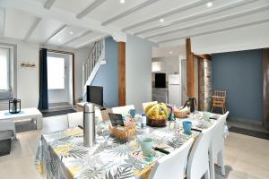 a dining room with a table with white chairs and a tableablish at Maison Castine - Maison pour 6 in Saint-Cast-le-Guildo