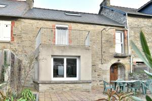 an old stone house with a patio and a table at Maison Castine - Maison pour 6 in Saint-Cast-le-Guildo