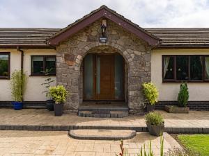 ein Haus mit einem Torbogen vor einer Tür in der Unterkunft Brookway Lodge in Holywell