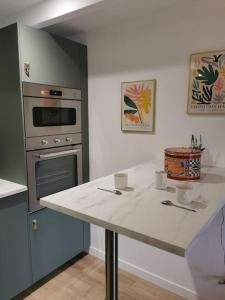 a kitchen with a white counter top and an oven at Propriété idéale pour coworking/voyage entreprise in Treillières