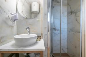 La salle de bains est pourvue d'un lavabo et d'une douche. dans l'établissement ALMIRA Studios Limnos 2, à Mirina