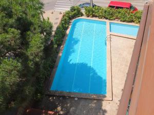 una vista aérea de una piscina azul con árboles en Apartment in front of the beach, en Castelldefels