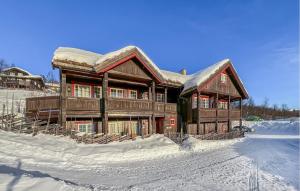 a large wooden house with snow on top of it at Stunning Apartment In Beitostlen With Kitchen in Beitostøl