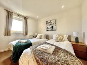 a bedroom with two beds and a window at Beachfront Bliss with Spectacular Views in Llanelli