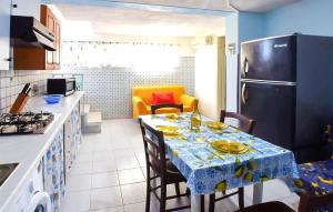 a kitchen with a table and a refrigerator at 1 Bedroom Amazing Apartment In Melito Porto Salvo in Melito di Porto Salvo
