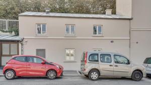 two cars parked in a parking lot in front of a house at 07 Tour Eiffel - Maison pour 5 personnes in Paris