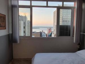 ein Schlafzimmerfenster mit Stadtblick in der Unterkunft De frente para o Guaíba. in Porto Alegre