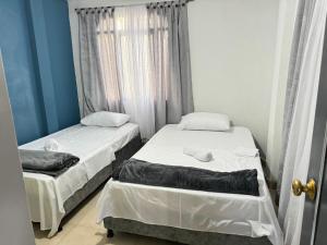 2 camas individuais num quarto com uma janela em Apartamento completo con terraza y piscina em Armênia