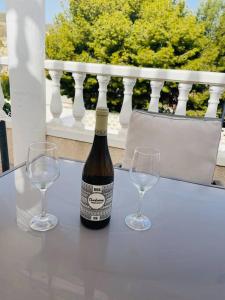 una botella de vino sentada en una mesa con dos copas de vino en Casa Blanca, en Alicante