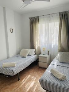 sypialnia z 2 łóżkami i oknem w obiekcie Casa Blanca w Alicante