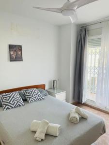sypialnia z dużym łóżkiem z dwoma ręcznikami w obiekcie Casa Blanca w Alicante