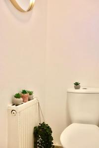 a bathroom with a toilet and potted plants on a radiator at Stunning Apartment Central London 1 bedroom Zone 1 Kennington, Sleeps 4 - Open for Long Stays and Families Relocating in London