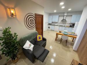 - un salon avec un canapé et une table dans l'établissement Apartamento entero Viento del Norte, à Sarón