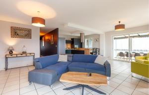 a living room with a blue couch and a kitchen at Beautiful Home In Six-Fours-Les-Plages in Six-Fours-les-Plages