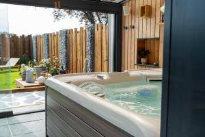eine Badewanne im Hof mit Terrasse in der Unterkunft Domaine de la Baie de Somme, suite Vanadis in Cayeux-sur-Mer