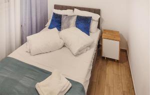 a bed with white sheets and blue pillows at Stunning Apartment In Grzybowo With Wi-fi in Grzybowo