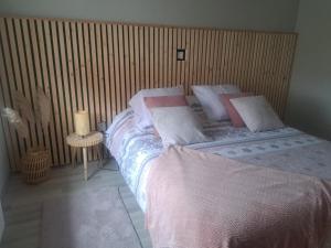 ein Schlafzimmer mit einem Bett und einer Holzwand in der Unterkunft le refuge du bonheur in Bitche