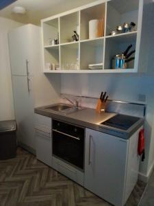a small kitchen with a sink and a stove at Apartment 13, Plants Yard in Worksop