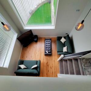 salon z zieloną kanapą i oknem w obiekcie Maple Gardens Studio w mieście Church Fenton