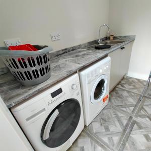 uma cozinha com uma máquina de lavar roupa e um lavatório em Maple Gardens Studio em Church Fenton