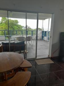 Habitación con mesa, sillas y balcón. en Indaba Manor Guesthouse, en Port Edward