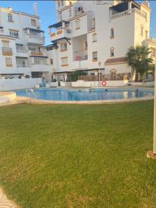 einem Pool vor einem großen Gebäude in der Unterkunft Apartº Roquetas de Mar 1º linea playa in Roquetas de Mar