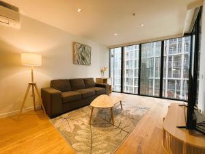 a living room with a couch and large windows at 2BR 1 Bath, Dockland, Marvel Stadium, Spacious in Melbourne