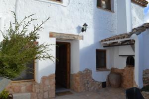 een wit gebouw met een deur in een tuin bij Casica de los Pastores in Alpera