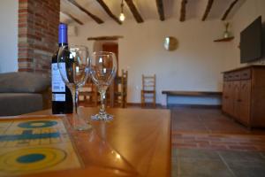 a bottle of wine and two wine glasses on a table at Casica de los Pastores in Ayora +18 photos