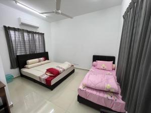 - 2 lits dans une chambre avec des draps roses dans l'établissement Sunny Lake House, à Behrang Hulu