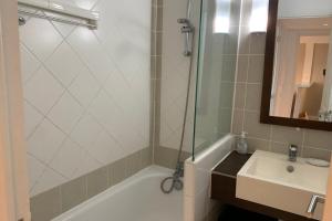 un bagno con vasca, lavandino e doccia di Bel appartement 5 pers avec piscine tennis et parking 236 a Le Touquet-Paris-Plage Altre 2 foto
