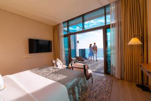 a hotel room with a bed and a view of the ocean at Bab Al Nojoum Hudayriyat Villas in Abu Dhabi