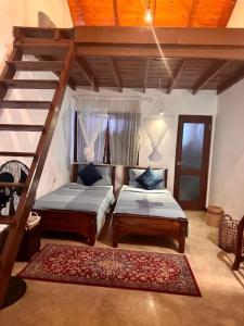 a bedroom with two beds and a stair case at Colonial Residence Kandy Villa in Kandy