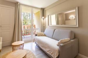 salon z kanapą i lustrem w obiekcie Beautiful flat with swimming pool tennis court and free parking 117 w mieście Le Touquet-Paris-Plage