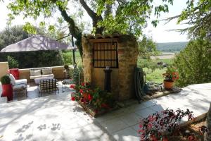 a patio with a table and chairs and an umbrella at Le Grand Saint Paul in Rognes