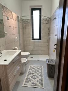 a bathroom with a sink and a toilet and a shower at Casa Bettina la Maddalena in La Maddalena