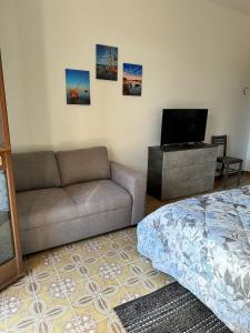 a living room with a couch and a flat screen tv at Casa Bettina la Maddalena in La Maddalena