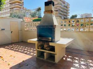 a outdoor pizza oven on a patio with buildings at Apartamento 1ª LINEA PLAYA MUCHAVISTA in El Campello
