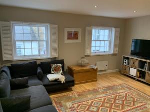 a living room with a couch and a tv at Lovely flat, balcony & woodstove, parking close in St. Agnes