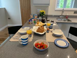 eine Küchentheke mit einem Frühstückstisch mit Obst und Saft in der Unterkunft Lovely flat, balcony & woodstove, parking close in St. Agnes  + 7 Fotos