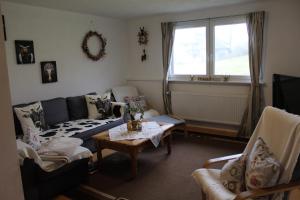 ein Wohnzimmer mit einem Sofa und einem Tisch in der Unterkunft Sport Rees - Ferienwohnung Melanie in Oberried