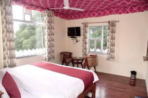 1 dormitorio con 1 cama, 2 ventanas y TV en Ranthambhore Tiger Niwas, en Sawāi Mādhopur