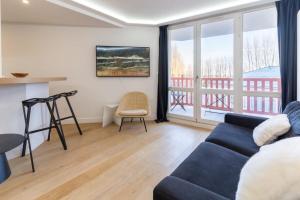 ein Wohnzimmer mit einem blauen Sofa und einem Balkon in der Unterkunft Beautiful flat with swimming pool tennis court and private car parking REF 148 in Le Touquet-Paris-Plage