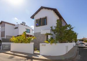 a white house with plants in front of it at Accomoteleia Blue Villa in Protaras