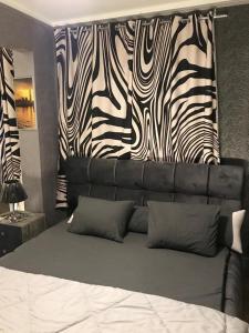 a bedroom with a bed with a head board with zebra print at جراند ماجيك استوديو in Cairo